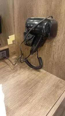 a black phone is hanging on a wall at منتجع وأكواخ غصن in Al Jafr