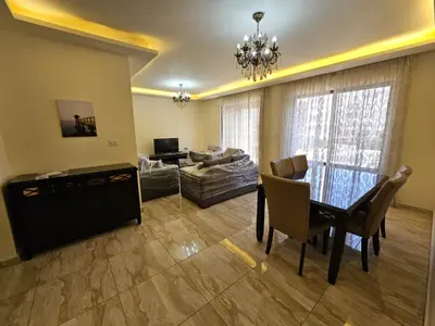 a living room with a dining table and a couch at MK7 - Two Bedroom Apartment in Amman