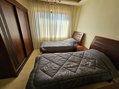 a hotel room with two beds and a window at MK7 - Two Bedroom Apartment in Amman