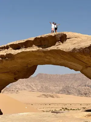 two people standing on a rock in the desert at Sultan Camp Wadi Rum in Wadi Rum