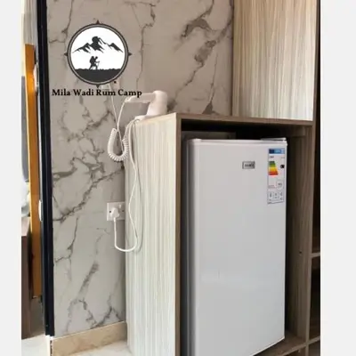 a refrigerator in a room with a marble wall at Mila Wadi Rum Camp in Wadi Rum