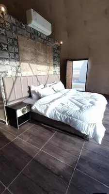 a bedroom with a large bed with white sheets at Wadi rum camp in Wadi Rum