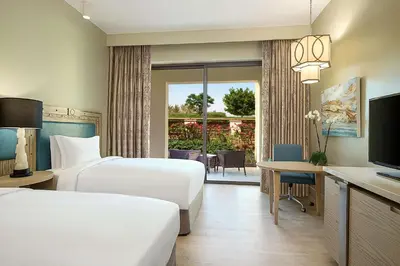 a hotel room with two beds and a television at Hilton Dead Sea Resort & Spa in Sowayma