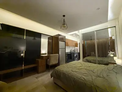 a bedroom with a bed and a desk and a kitchen at Swefieh studio 8 in Amman