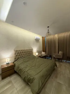 a bedroom with a large bed and a chair at Swefieh studio 8 in Amman