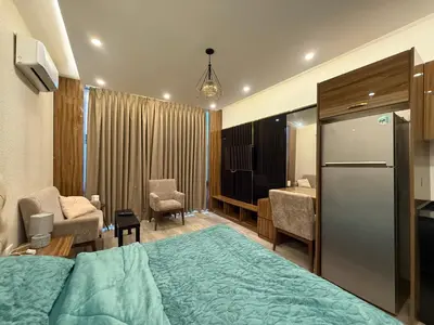 a hotel room with a bed and a kitchen at Swefieh studio 8 in Amman