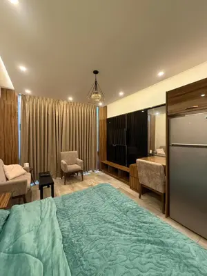 a hotel room with a large bed and a desk at Swefieh studio 8 in Amman