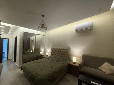 a hotel room with two beds and a couch at Swefieh studio 8 in Amman