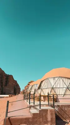 a glass building in the middle of a desert at Ahmad desert camp wadi rum in Wadi Rum