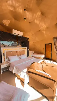 a bedroom with two beds and a wooden ceiling at Ahmad desert camp wadi rum in Wadi Rum