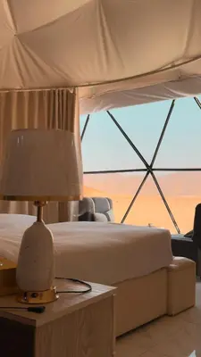 a bedroom with a bed and a lamp on a table at Ahmad desert camp wadi rum in Wadi Rum