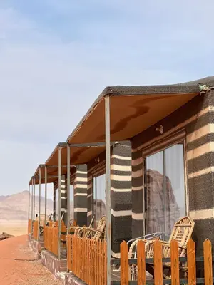 a group of chairs sitting outside of a building in the desert at Golden Stars Luxury Camp Wadi Rum in Wadi Rum