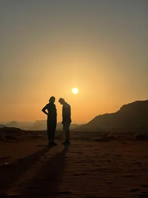 two people standing in the desert watching the sunset at Local experience in El Quweira