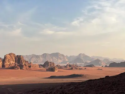 a view of the desert with mountains in the background at Local experience in El Quweira