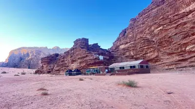 a building in the desert next to a mountain at Wadi rum Breeze of calm in Wadi Rum