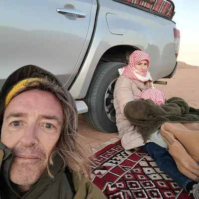a man and a girl sitting next to a truck at Wadi rum Breeze of calm in Wadi Rum