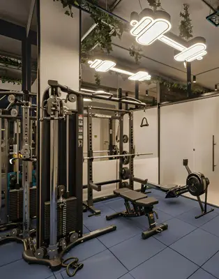 a gym with several treadmills and weights at April Hotel in Aqaba