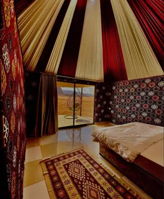 a bedroom with a bed and a window and a rug at Nile Bedouin Camp in Disah
