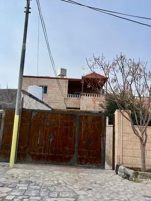 a wooden gate in front of a house at Lozi House Cozy Stay in Al Azraq ash Shamālī