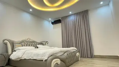 a bedroom with a large bed and a chandelier at Villa W2 in Amman