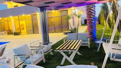 a patio with chairs and a wooden table and chairs at Villa W2 in Amman