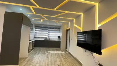 a living room with a television and a kitchen at Villa W2 in Amman