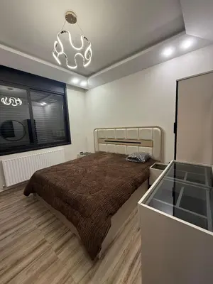 a bedroom with a bed and a window and a chandelier at Luxury apartment شقة فخمة in Amman