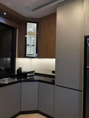 a kitchen with white cabinets and a refrigerator at Luxury apartment شقة فخمة in Amman