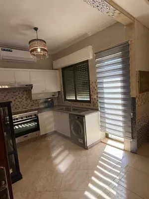 a kitchen with a stove and a microwave at Furnished luxurious apartment with a stunning view near Kling Hussein Business Park in Amman