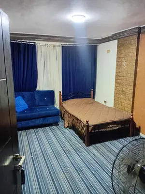 a bedroom with a bed and a blue couch at Royal Homes Jordan in Amman