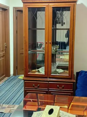 a wooden cabinet with glass doors in a living room at Royal Homes Jordan in Amman
