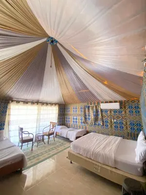 a bedroom with two beds and a tent at Siella Pearl of Wadi Rum in Wadi Rum