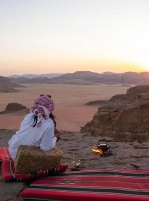 a couple sitting in the desert watching the sunset at Siella Pearl of Wadi Rum in Wadi Rum