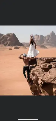 a bride and groom standing on a rock in the desert at Luxury Wadi Rum Camp in Wadi Rum