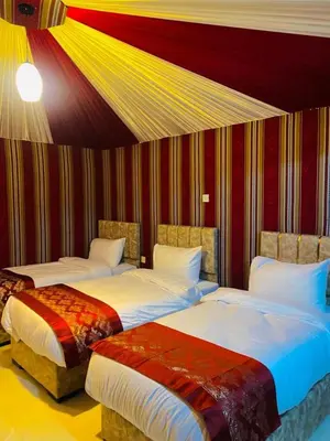 two beds in a room with red and yellow stripes at Luxury Wadi Rum Camp in Wadi Rum