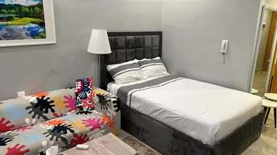 a small bedroom with a bed and a couch at Pasha Holiday - DAMAC Tower in Amman