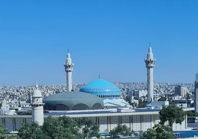 a mosque with two towers and a city in the background at Pasha Holiday - DAMAC Tower in Amman
