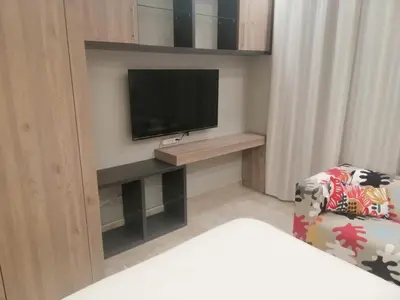 a living room with a television and a chair at Pasha Holiday - DAMAC Tower in Amman