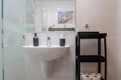 a bathroom with a sink and a glass shower at Weibdeh Oasis 2 Bedroom in Amman