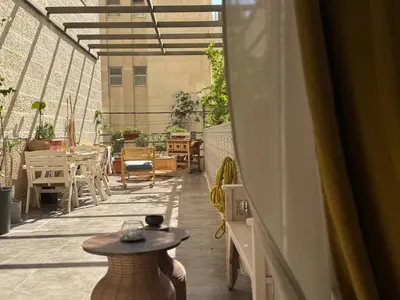 an outdoor patio with a table and chairs on a balcony at Weibdeh Oasis 2 Bedroom in Amman