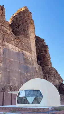 a dome building in front of a rock wall at Silent Sands in Wadi Rum