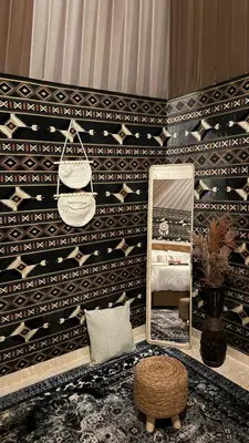 a bedroom with a mirror and a bed and a stool at Wadi rum camp Ausama in Wadi Rum