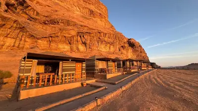 a building in the desert next to a mountain at Wadi rum camp Ausama in Wadi Rum