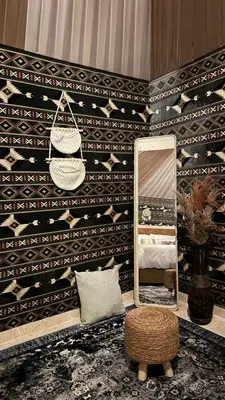 a mirror and a chair in a room with a wall at Wadi rum camp Ausama in Wadi Rum