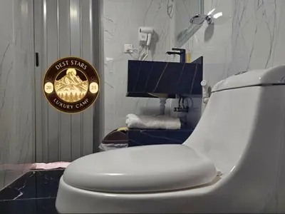 a white toilet in a bathroom with a sign on it at DESRT STARS lUXURY CAMP in Disah