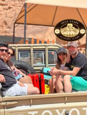 a group of people sitting in the back of a truck at DESRT STARS lUXURY CAMP in Disah