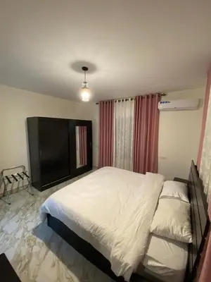 a bedroom with a large bed and a television at Travelers Choice Apartment Near Petra in Wadi Musa