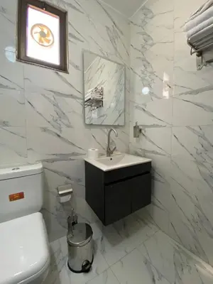 a white bathroom with a sink and a toilet at Travelers Choice Apartment Near Petra in Wadi Musa
