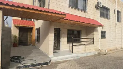 an outside view of a building with a red roof at اربد لواء الوسطية كفرعان مجسم البتراء