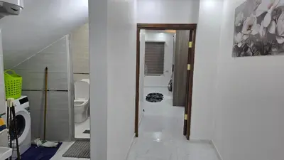 a bathroom with a toilet and a sink and a hallway at اربد لواء الوسطية كفرعان مجسم البتراء